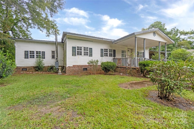 rear view of property featuring a yard and covered porch