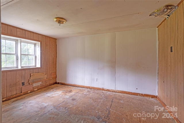 spare room with wood walls