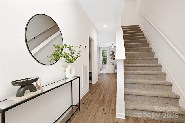 stairway featuring hardwood / wood-style flooring and ceiling fan