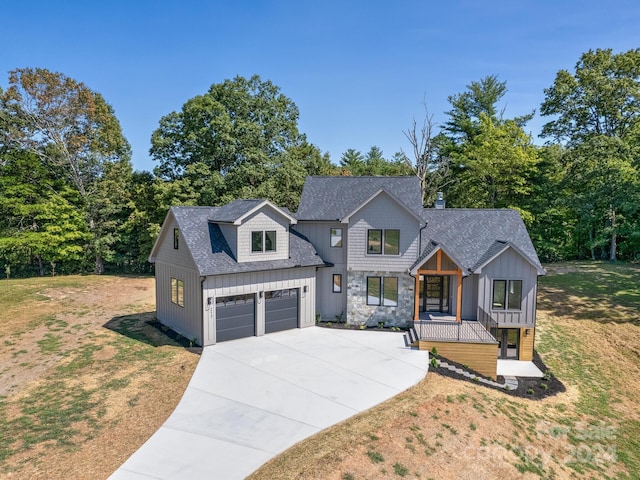 modern inspired farmhouse with a garage and a front lawn