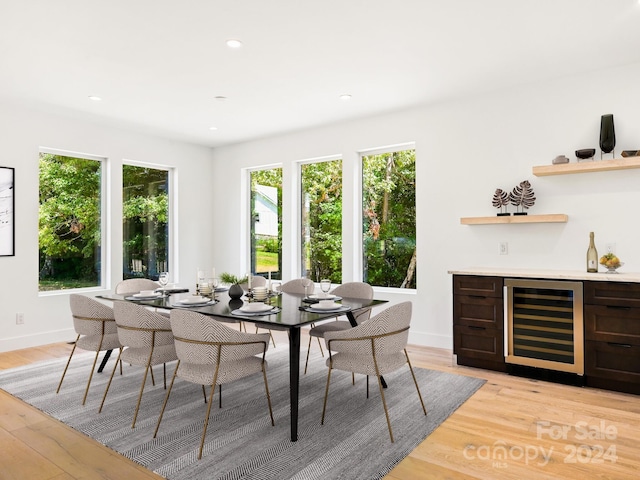 dining area with beverage cooler and light wood-type flooring