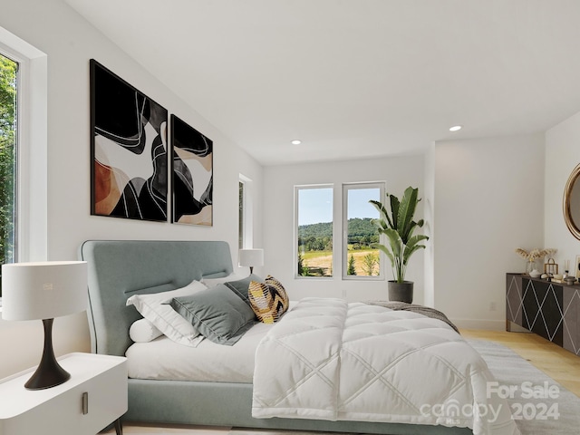 bedroom featuring multiple windows and light hardwood / wood-style flooring