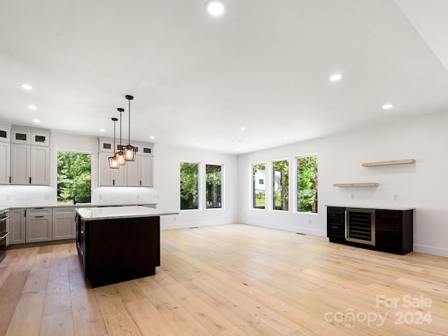 kitchen with plenty of natural light, pendant lighting, a center island, and light hardwood / wood-style flooring