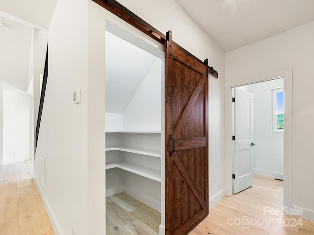 hall featuring light hardwood / wood-style flooring and a barn door