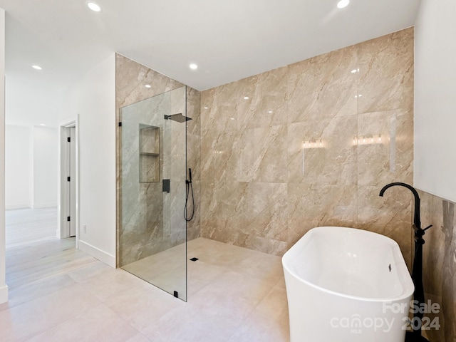 bathroom featuring tile walls, tile patterned floors, and plus walk in shower