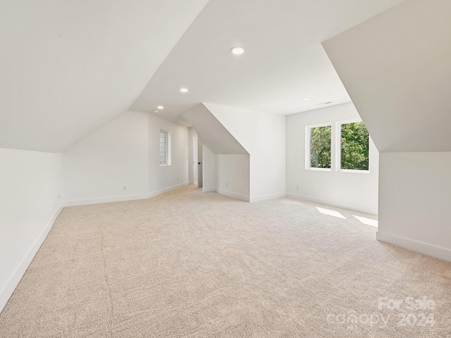 bonus room featuring light carpet and vaulted ceiling