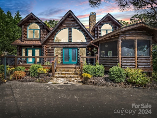 181 Highland Hts, Lake Lure, NC 28746 - log home with a sunroom, log siding, french doors, a chimney, and a wooden deck