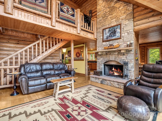 living room with wooden ceiling, a stone fireplace, high vaulted ceiling, and hardwood / wood-style flooring