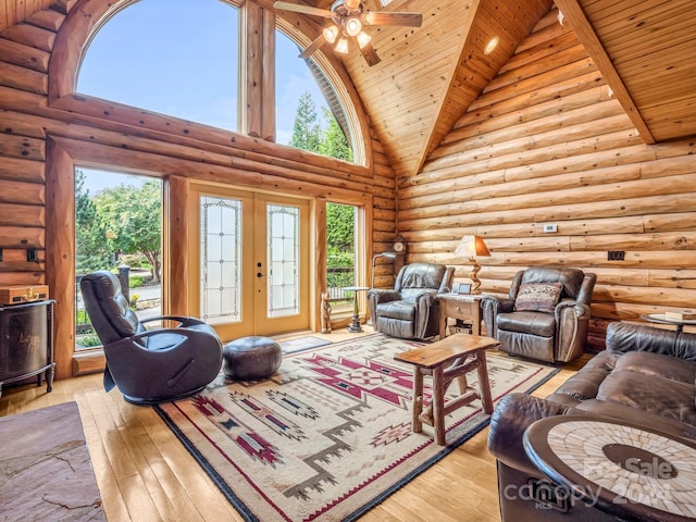 living room featuring high vaulted ceiling, light wood-type flooring, beam ceiling, and ceiling fan