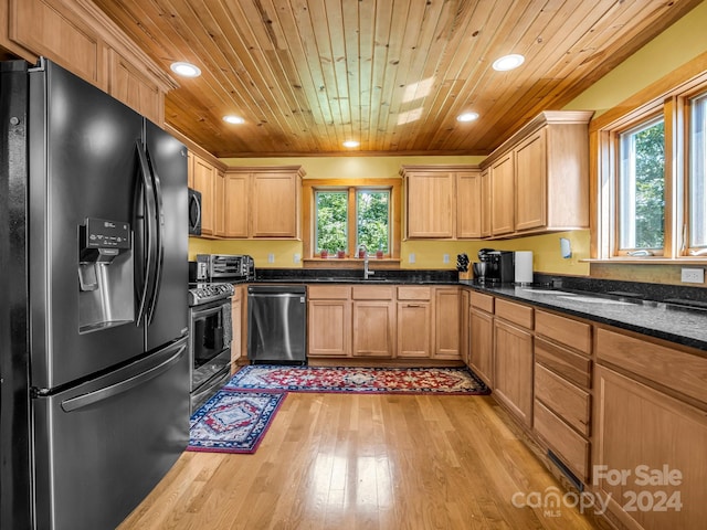 kitchen with a wealth of natural light, light wood-type flooring, wood ceiling, and black appliances