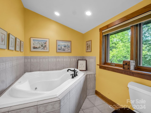 bathroom featuring lofted ceiling, tiled bath, toilet, and tile patterned floors