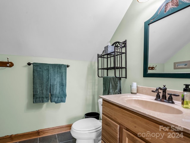 bathroom featuring vaulted ceiling, vanity, toilet, and tile patterned floors