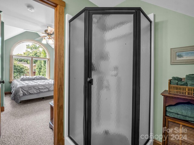 bathroom featuring lofted ceiling, ceiling fan, and a shower with door