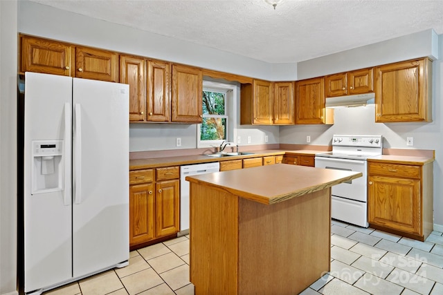 kitchen featuring a textured ceiling, white appliances, a center island, and sink