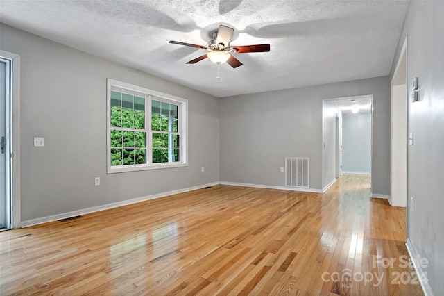 spare room featuring a textured ceiling, light hardwood / wood-style floors, and ceiling fan