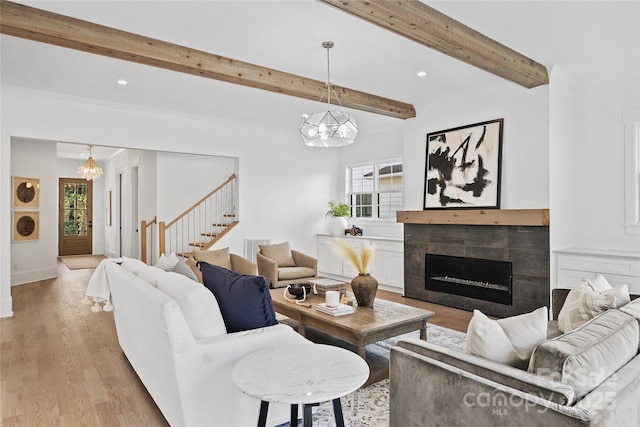 living room featuring light hardwood / wood-style flooring, beamed ceiling, plenty of natural light, and a fireplace