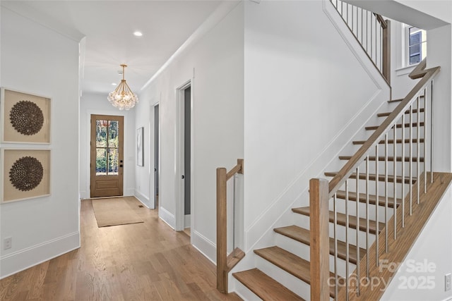 foyer with light hardwood / wood-style flooring and an inviting chandelier