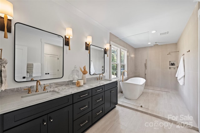 bathroom featuring tile patterned floors, plus walk in shower, and vanity