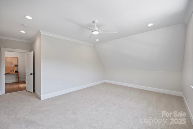 carpeted spare room featuring ceiling fan, lofted ceiling, and crown molding