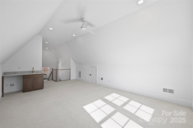 additional living space with sink, light carpet, lofted ceiling, and ceiling fan