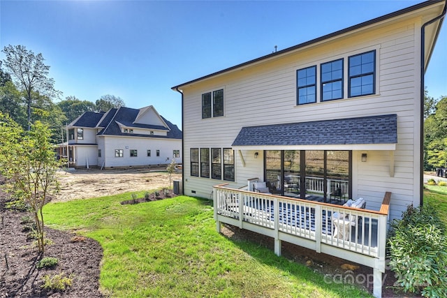 rear view of house with a deck, central air condition unit, and a lawn