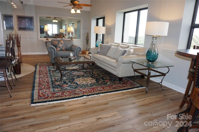 living room featuring light hardwood / wood-style floors, ceiling fan, and plenty of natural light