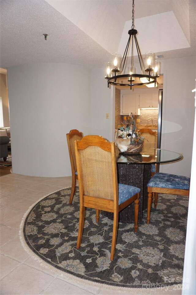 dining room with light tile patterned floors, a textured ceiling, and a chandelier