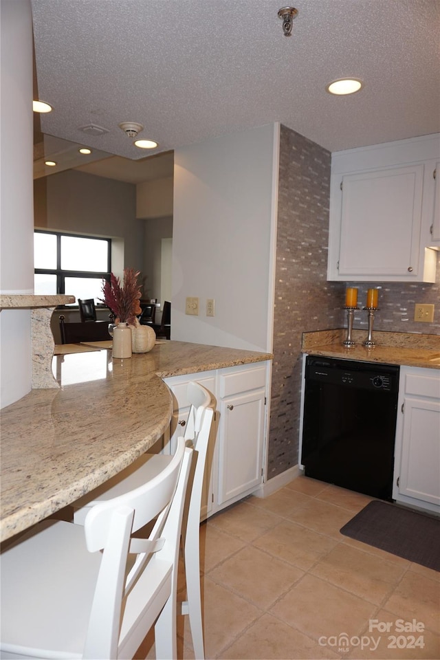 kitchen featuring a textured ceiling, white cabinetry, dishwasher, and light stone counters