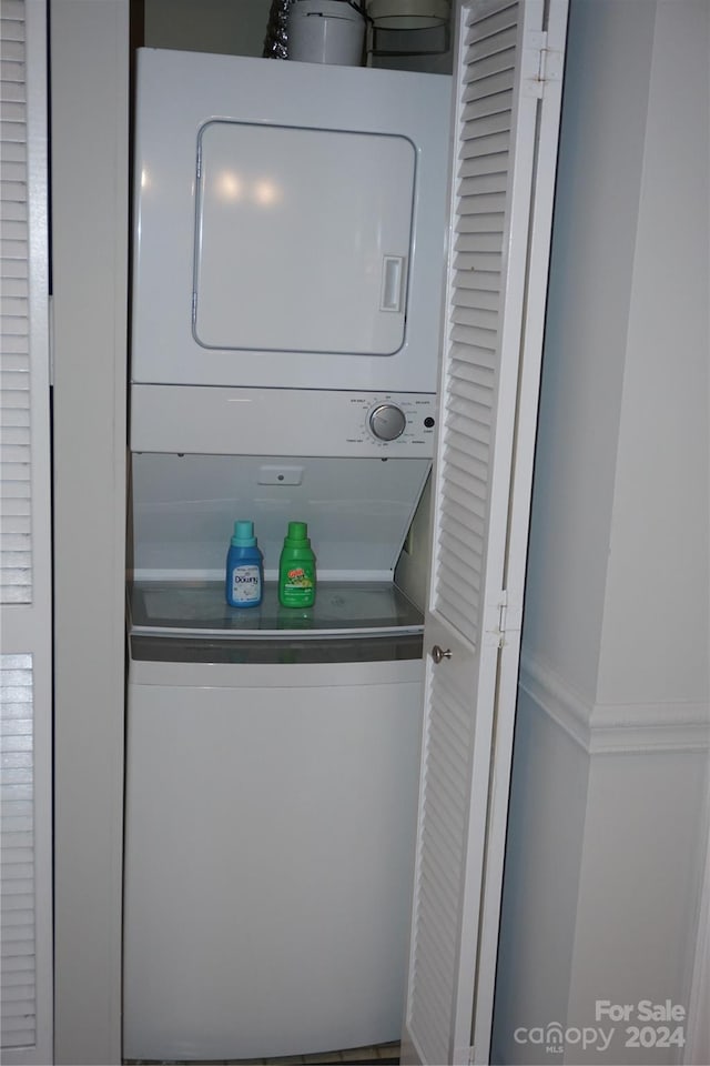 clothes washing area featuring stacked washer / dryer