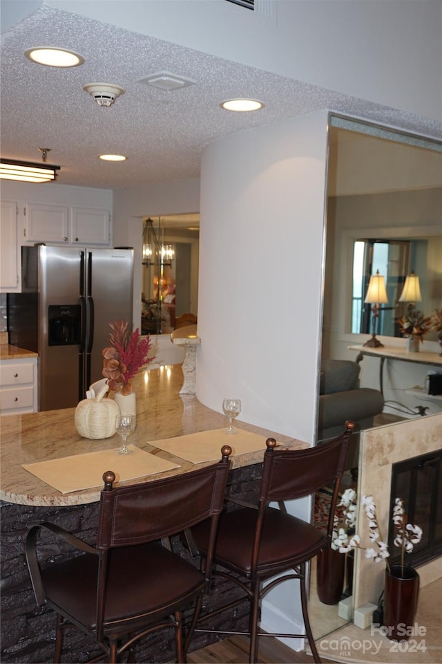 dining space featuring a textured ceiling, an inviting chandelier, and hardwood / wood-style flooring