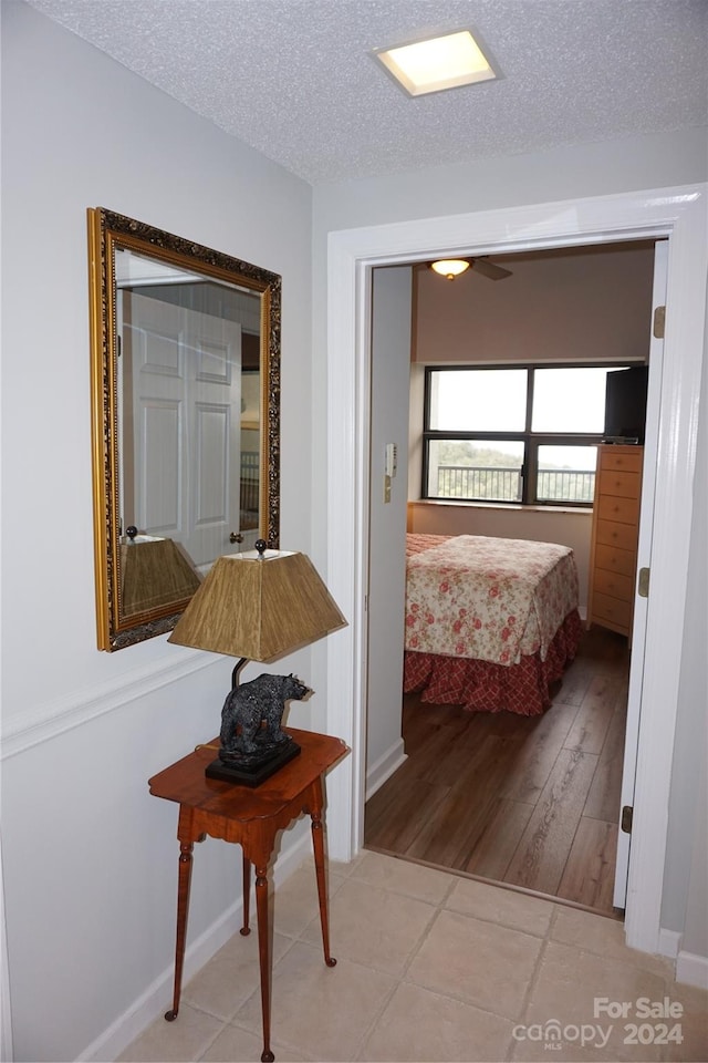 bedroom featuring a textured ceiling, ceiling fan, and light hardwood / wood-style flooring