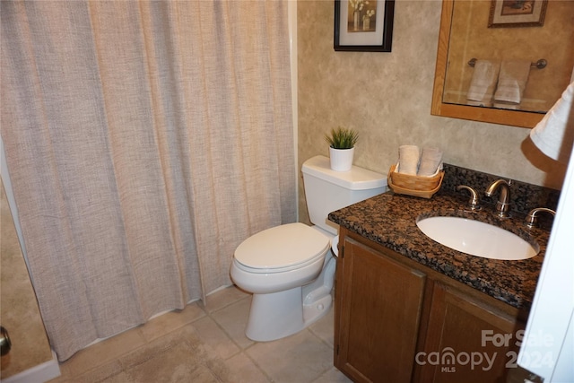 bathroom featuring a shower with shower curtain, tile patterned flooring, vanity, and toilet