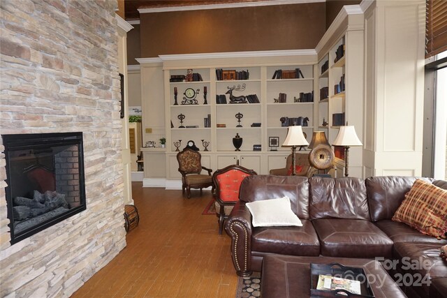 living room with a fireplace, ornamental molding, and hardwood / wood-style floors