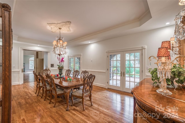 dining area featuring a healthy amount of sunlight, wood-type flooring, and french doors