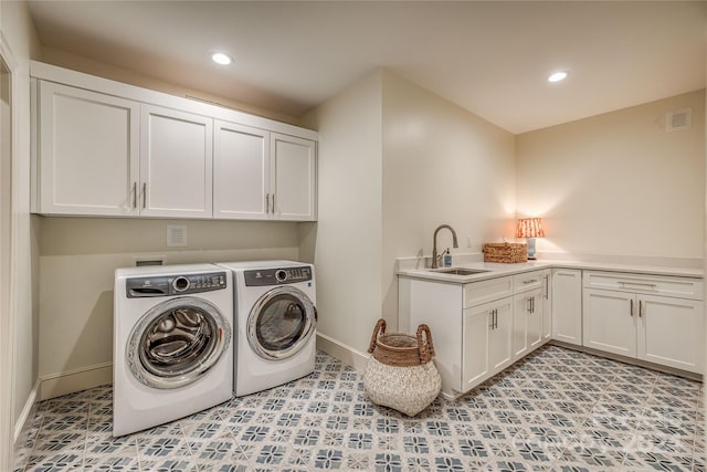 laundry room featuring sink, washer and dryer, and cabinets