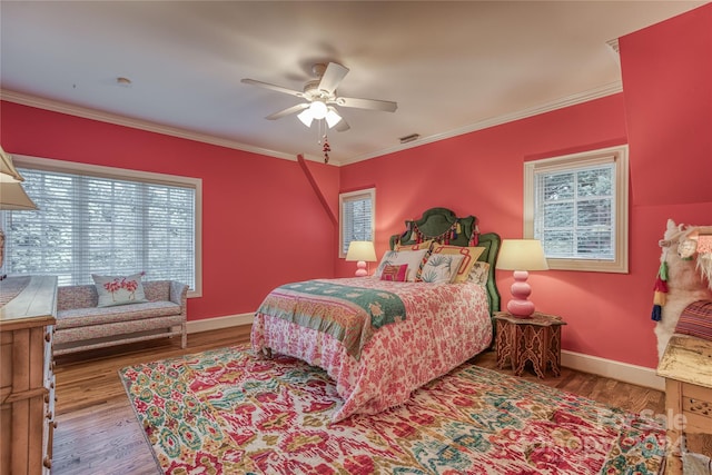 bedroom featuring ceiling fan, ornamental molding, and wood-type flooring