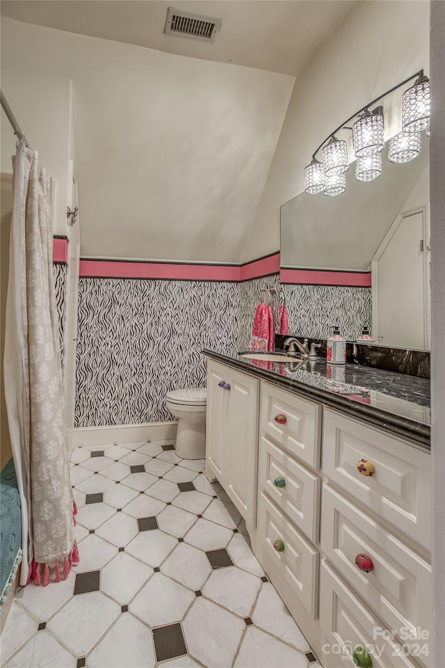 bathroom featuring vaulted ceiling, vanity, and toilet