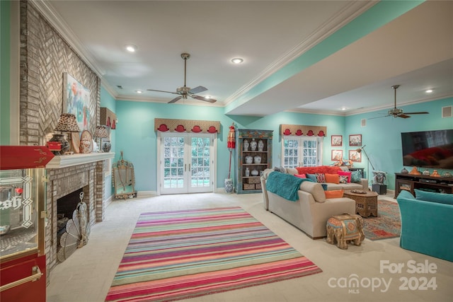 living room with a brick fireplace, light carpet, ornamental molding, and ceiling fan