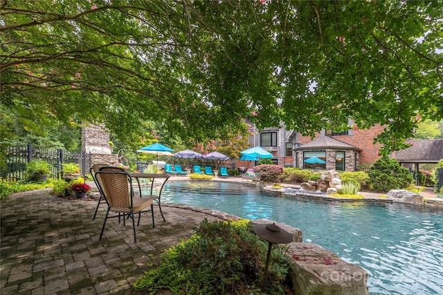 outdoor pool with a patio and fence