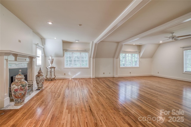 unfurnished living room featuring recessed lighting, wood finished floors, a ceiling fan, baseboards, and a tiled fireplace