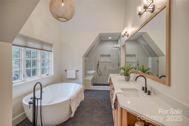 full bath with tile patterned flooring, a sink, a freestanding bath, a shower stall, and double vanity