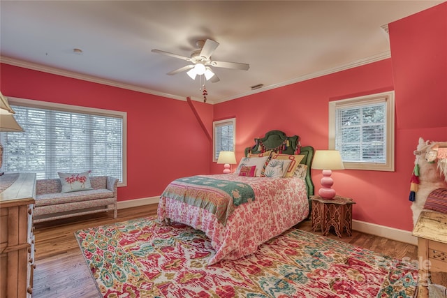 bedroom featuring crown molding, baseboards, and wood finished floors