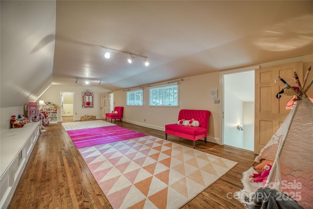 rec room featuring lofted ceiling, wood finished floors, rail lighting, and baseboards