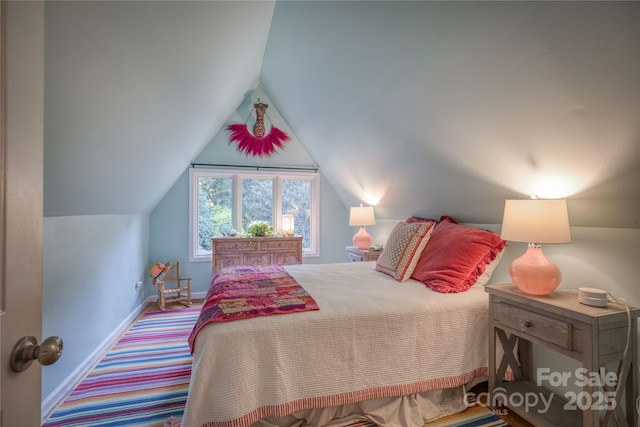 bedroom featuring lofted ceiling, baseboards, and carpet flooring