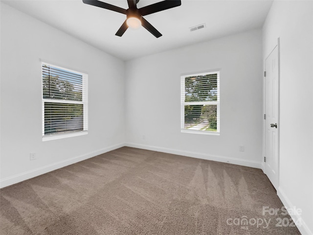 unfurnished room featuring ceiling fan and carpet