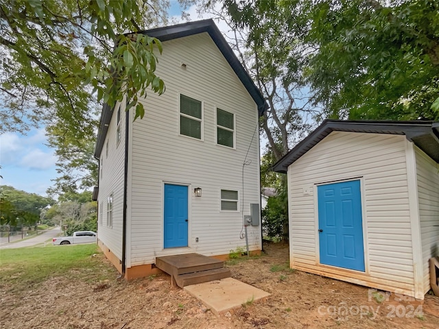 rear view of property with a storage shed