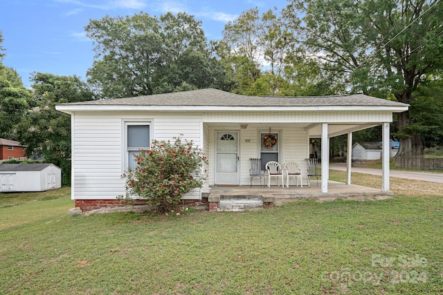 view of front of home featuring a storage shed and a front lawn