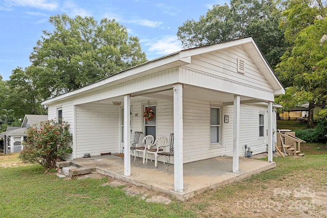 view of front facade featuring covered porch and a front yard