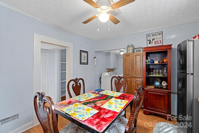 dining space featuring light wood-type flooring, washer / dryer, a textured ceiling, and ceiling fan