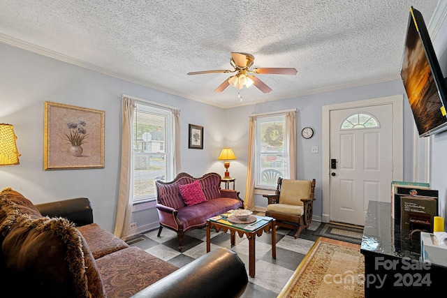 living room with a textured ceiling, ceiling fan, ornamental molding, and light tile patterned flooring